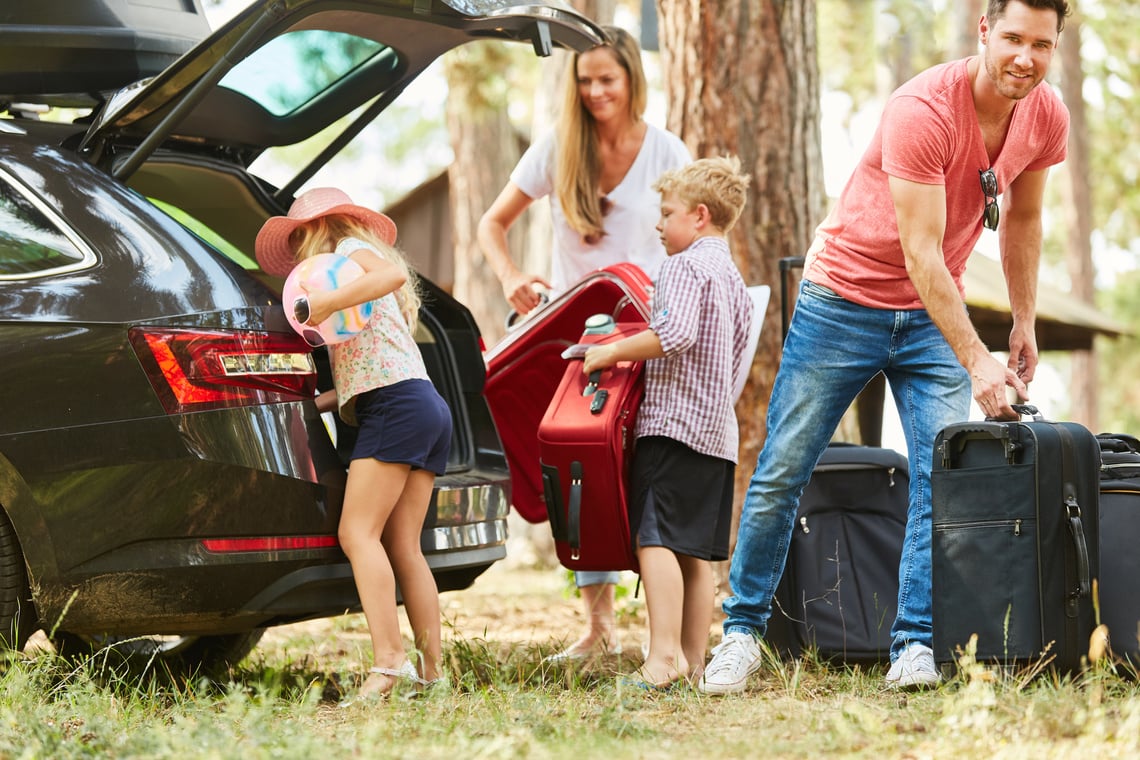 Family Packing Suitcases at the Car